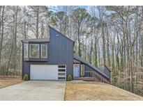 Modern home with gray siding, white garage door, and wood deck at 3214 Cedar Bluff Ne Dr, Marietta, GA 30062