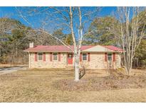 Brick ranch house with red roof, red shutters, and a yard at 1946 Christian Se Cir, Conyers, GA 30013