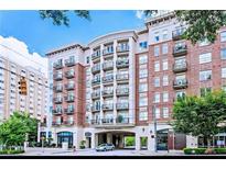 Elegant condominium building featuring brick facade, multiple balconies, and street-level retail at 2277 Peachtree Ne Rd # 405, Atlanta, GA 30309
