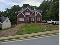 Brick two-story house with landscaped yard and driveway at 2710 Factor Walk Blvd, Suwanee, GA 30024