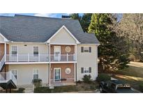 Two-story townhome with neutral siding and a balcony at 1709 Bald Ridge Marina Rd # 4, Cumming, GA 30041