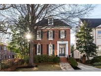 Brick three-story home with stone pathway, landscaping, and a large tree in front at 3674 Kingsboro Ne Rd, Atlanta, GA 30319