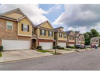 Charming townhomes featuring attached garages, brick accents and landscaped lawns at 53 Providence Oak Ct, Lawrenceville, GA 30046