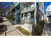 Charming townhouse with brick facade, blue door, black railings, and a small front yard at 711 Needletail Way, Atlanta, GA 30312