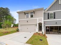 Tan and gray two-story townhome with attached garage and landscaping at 163 Bluffington Way, Marietta, GA 30066