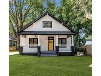 Charming craftsman bungalow with a yellow door, front porch, and manicured lawn at 1120 Arlington Ave, Atlanta, GA 30310
