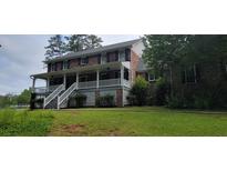 Charming two-story brick home featuring a welcoming front porch with white railing and landscaped yard at 1294 Dogwood Rd, Snellville, GA 30078
