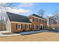 Brick home with a two-car garage and well-manicured lawn at 3050 Wax Wing Nw Ct, Kennesaw, GA 30144