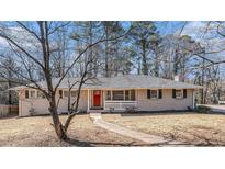 Brick ranch house with red door, walkway, and mature trees at 475 Shannon Way, Lawrenceville, GA 30044