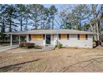 Brick ranch house with mature trees, needing repairs at 1967 Glen Echo Dr, Decatur, GA 30032