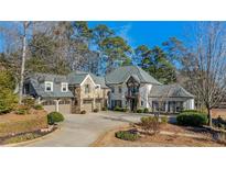 Stunning stone house with a large driveway and mature trees at 571 Glen Eagles Se Cir, Marietta, GA 30067