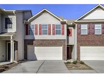 Two-story townhome with attached garage and red shutters at 177 Oakland Hills Way, Lawrenceville, GA 30044