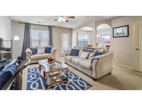 Cozy living room featuring neutral walls, plush sofas, and a stylish blue patterned rug at 177 Oakland Hills Way, Lawrenceville, GA 30044