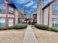 Exterior view of condo building with walkway and landscaping at 713 Cypress Pointe St, Alpharetta, GA 30022