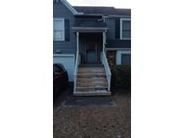 Gray siding house with wooden stairs and a security door at 390 Lakeridge Ct, Riverdale, GA 30274