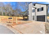 Renovated two-story house with a modern exterior, driveway, and fenced yard at 459 Orchard Dr, Stone Mountain, GA 30083