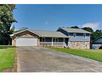 Ranch style home with a two-car garage and a spacious front yard at 532 Greg Sw Dr, Lilburn, GA 30047