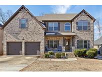 Two-story brick home with a two-car garage and landscaped yard at 527 Mossycup Dr, Fairburn, GA 30213