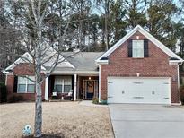 Brick home with 2-car garage, rocking chairs on porch, and landscaped yard at 4334 Austin Farm Trl, Acworth, GA 30101