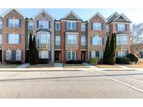 Front view of three townhouses with brick and siding exteriors at 6033 Bayrose Cir # 33A, East Point, GA 30344