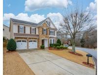 Two-story house with stone accents and a three-car garage at 12548 Kensington Blvd, Alpharetta, GA 30005