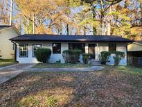 Newly renovated Ranch home featuring a white brick exterior, black windows, and landscaping at 188 Oak Dr, Atlanta, GA 30354