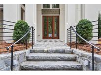 Inviting entryway with stone steps, iron railings, and a double wood door at 94 Sheridan Dr, Atlanta, GA 30305