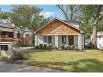 Charming craftsman bungalow with white brick, wood accents, and a manicured lawn at 458 Holly Nw St, Atlanta, GA 30318
