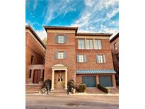Charming brick townhome with blue shutters and a two-car garage, showcasing classic architectural details at 5890 Bond St, Cumming, GA 30040