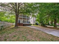 Two-story house with front porch and driveway, surrounded by lush green trees at 59 Stafford Nw St, Atlanta, GA 30314