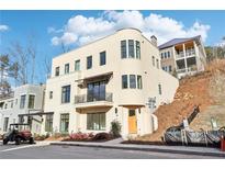 Tan three-story home with balcony and modern design at 10861 Serenbe Ln, Chattahoochee Hills, GA 30268