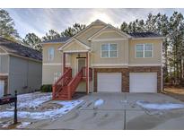 Tan two-story house with two car garage, red stairs and landscaping at 113 Omega Ct, Dallas, GA 30157