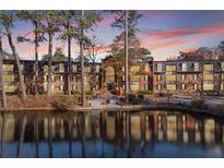 Attractive brick building with pond reflection at sunset at 23304 Plantation Ne Dr # 304, Atlanta, GA 30324