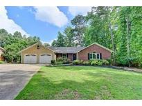 Brick ranch house with attached two-car garage and landscaped lawn at 2842 Cardinal Lake Dr, Duluth, GA 30096