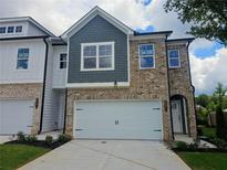 Modern two-story home with gray and brick exterior, attached garage, and landscaping at 5571 Hislop Ln # 41, Mableton, GA 30126