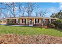 Charming brick home with a well-manicured lawn and inviting front porch at 3660 Hickory Se Cir, Smyrna, GA 30080