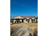 Ranch style home with a paved driveway and well-maintained lawn at 415 Dove Ln, Social Circle, GA 30025