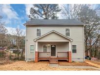 Charming two-story home with a covered front porch and a well-maintained yard at 1580 Mary George Nw Ave, Atlanta, GA 30318