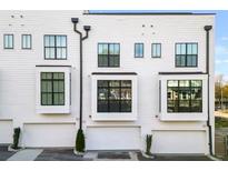 Modern rear exterior of townhome with white siding, black windows, and attached garage at 85 Boulevard Ne, Atlanta, GA 30312