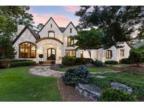 Charming two-story home with stone and brick accents, arched entry, and professional landscaping at 4874 Kettle River Pt, Suwanee, GA 30024