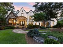 Elegant two-story home with stone accents and manicured landscaping at 4874 Kettle River Pt, Suwanee, GA 30024