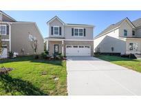 Two-story home with gray siding, brick accents, and a two-car garage at 11827 Rizvan Pl, Covington, GA 30014