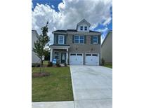 Charming two-story home with a well-manicured lawn, two-car garage, and classic architectural details at 11831 Rizvan Pl, Covington, GA 30014