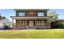 Two-story house with green and brown siding, a large front porch, and a well-manicured lawn at 1432 Mims Sw St, Atlanta, GA 30314