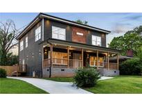 Charming two-story home featuring a welcoming porch, complemented by a well-manicured lawn and a concrete driveway at 1432 Mims Sw St, Atlanta, GA 30314