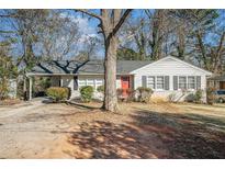 Charming one-story house with red door, mature tree, and spacious yard at 1603 Hollyhock Ter, Decatur, GA 30032