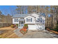 House exterior showcasing a two-car garage and well-manicured lawn at 304 Stations Ave, Woodstock, GA 30189