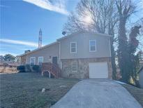 Two-story house with stone accents, attached garage, and a wooden deck at 3690 Darrah Sw Way, Atlanta, GA 30331