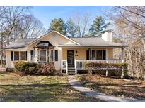 Inviting yellow house with a wraparound porch and landscaped yard at 51 Willow Bend Nw Dr, Cartersville, GA 30121