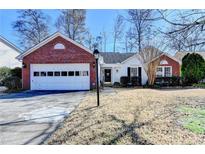 Brick and white ranch home with attached garage and landscaped yard at 3070 Abbotts Pointe Dr, Duluth, GA 30097